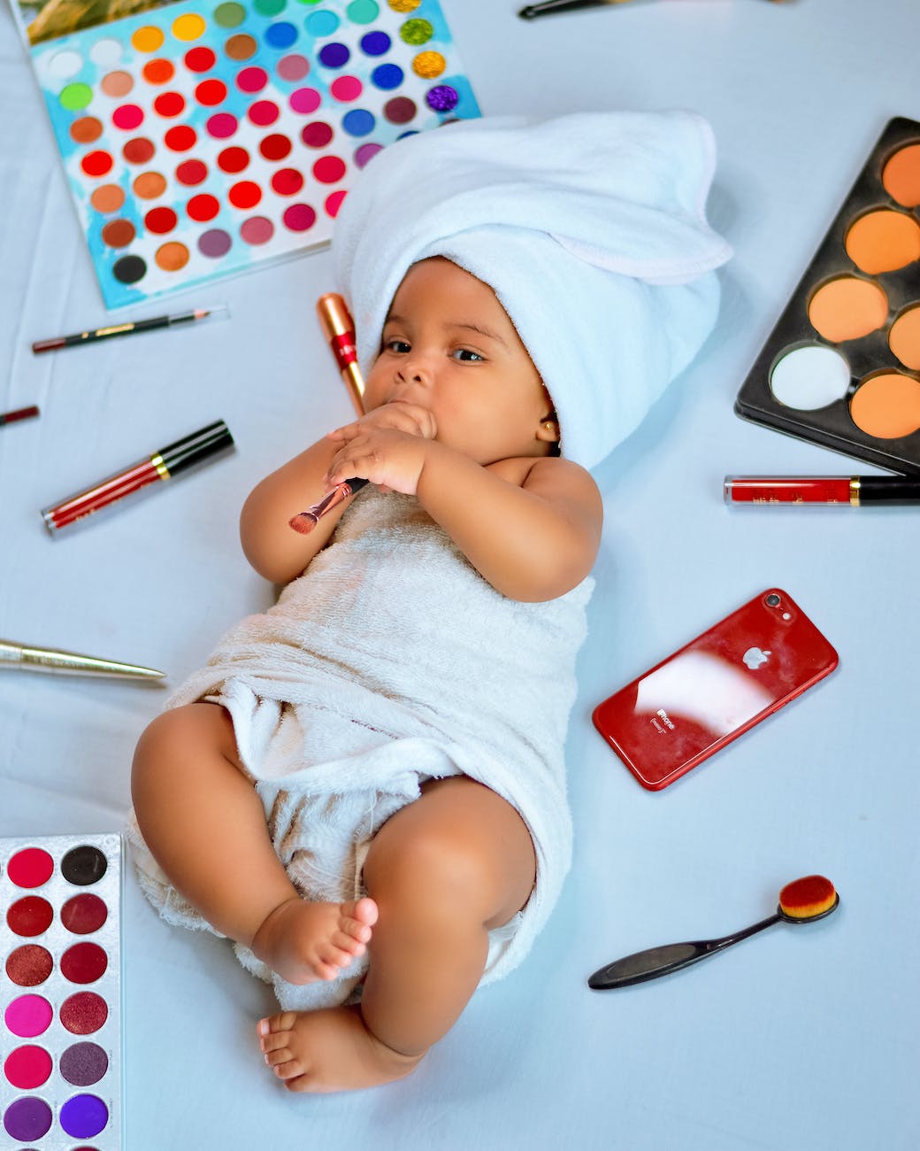 a baby surrounded with cosmetic products