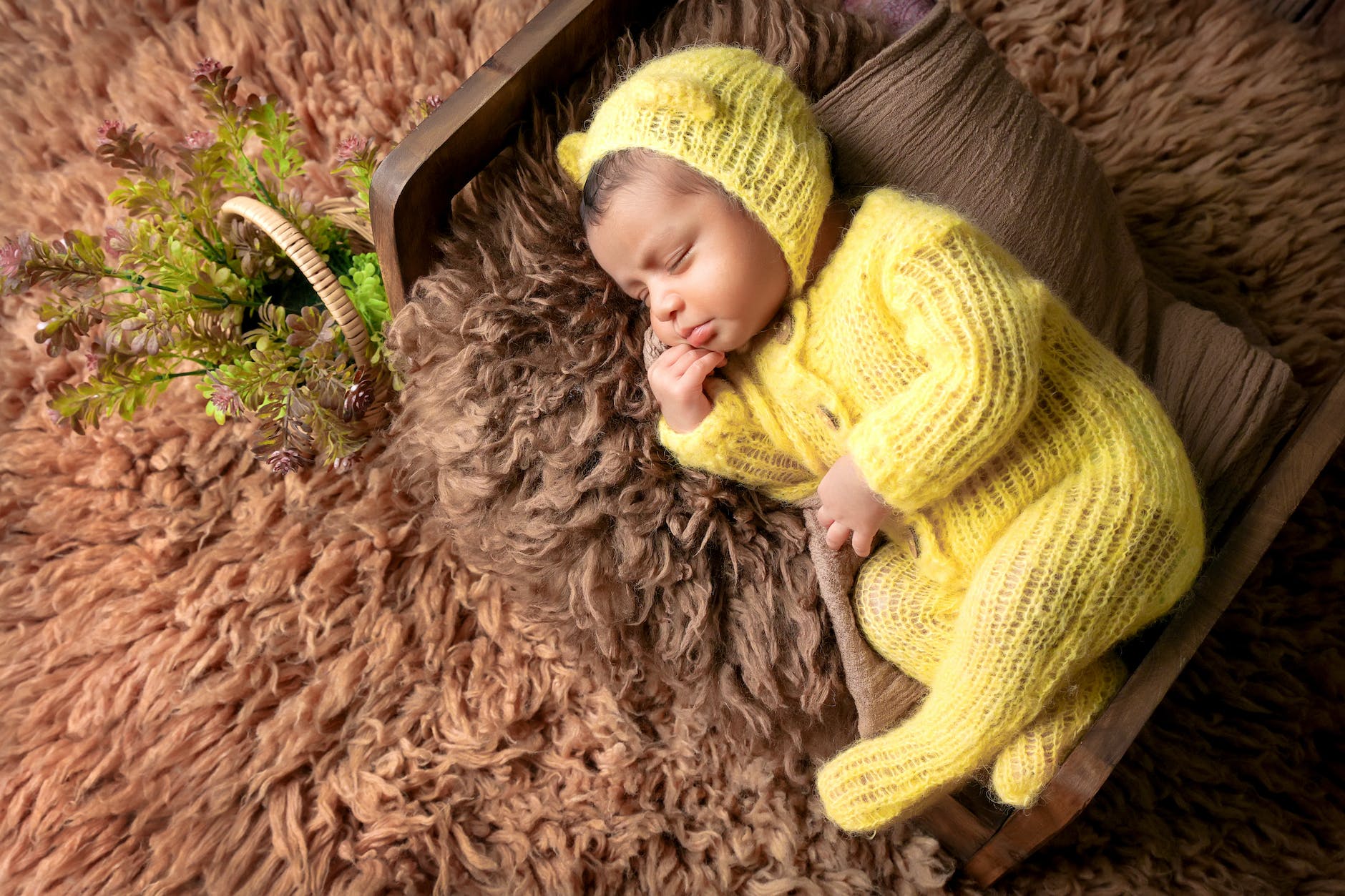 little baby in yellow rompers on a fuzzy blanket