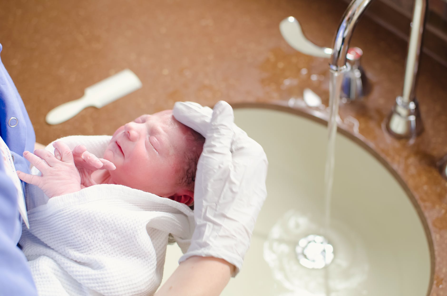 a person bathing the baby