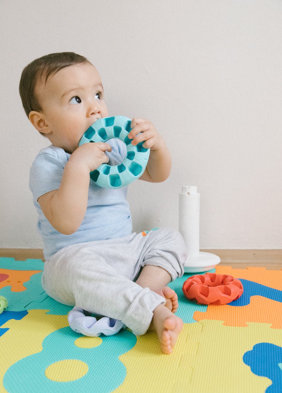 baby on puzzle mat playing toys