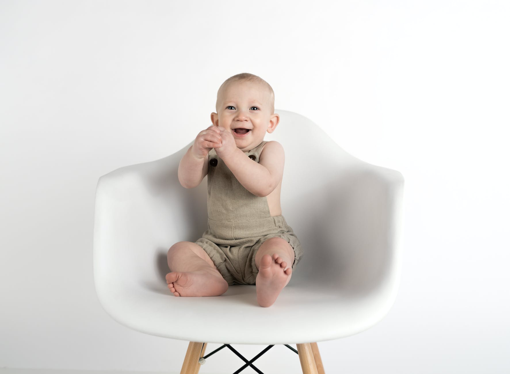 baby sitting on white chair